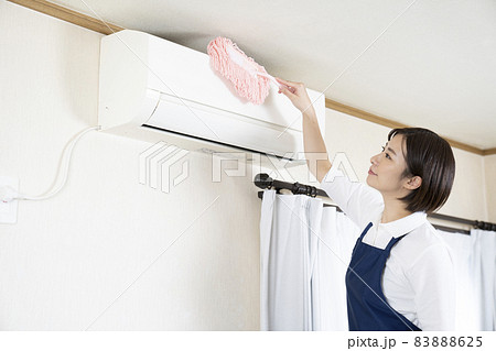 ハンディモップでエアコンの清掃をする女性 83888625