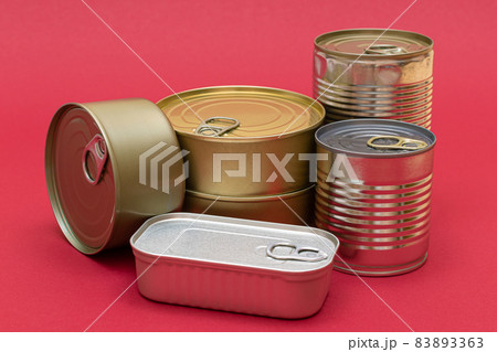 Unopened Tin Cans with Blank Edges on Red Background 83893363