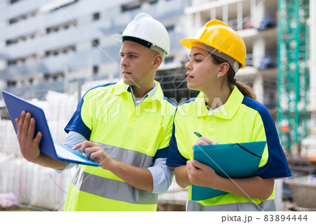 Two builders planning their work in construction plant 83894444