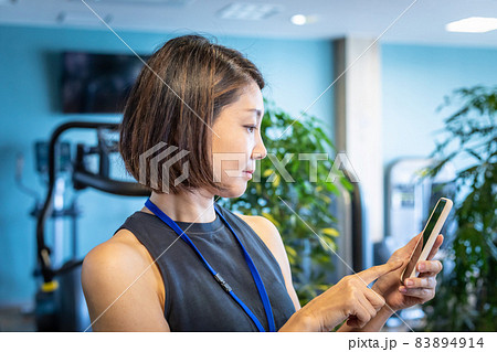 スポーツジムで働くスポーツトレーナー(スマホ) スポーツジムで働くスポーツトレーナー(スマホ) 83894914