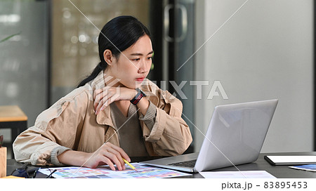 Young female graphic designer working with computer laptop in creative office. 83895453