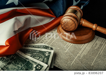 Wooden judge mallet with Dollars notes on the USA flag with Declaration of Independence Wooden judge mallet with Dollars notes on the USA flag with Declaration of Independence 83896207