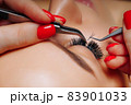 Eyelash Extension Procedure. Woman Eye with Long Eyelashes. Close up, selective focus. 83901033