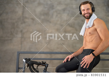 Cheerful young man having stationary bike workout at home 83901531