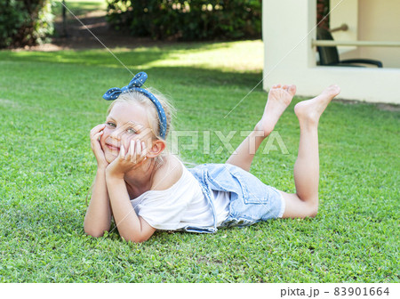 Little girl lying on green grass Little girl lying on green grass 83901664