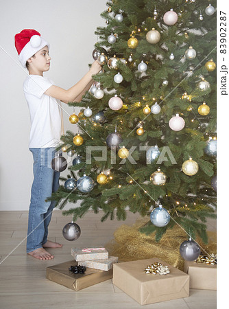Boy with gifts plays near the Christmas tree 83902287