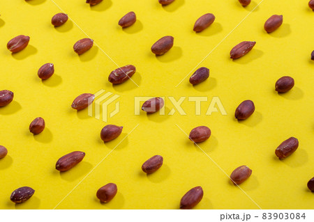Pattern of peanuts. Fashionable sunny pattern of peanuts on yellow background. Pattern of peanuts. Fashionable sunny pattern of peanuts on yellow background. 83903084
