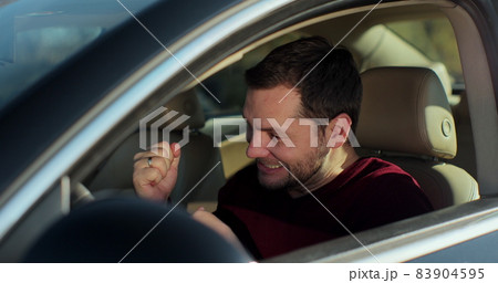 Close up of woman hand giving keys to young man that sitting in new car. Happy auto owner buying transport at modern salon. 83904595