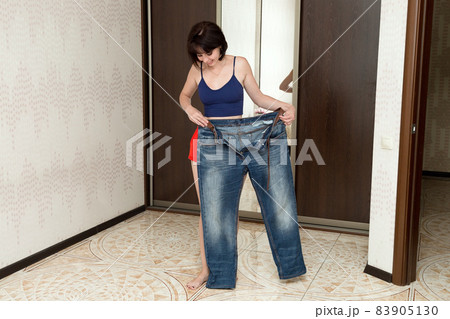 A woman shows off her slim figure, showing off big jeans, a slimming concept 83905130