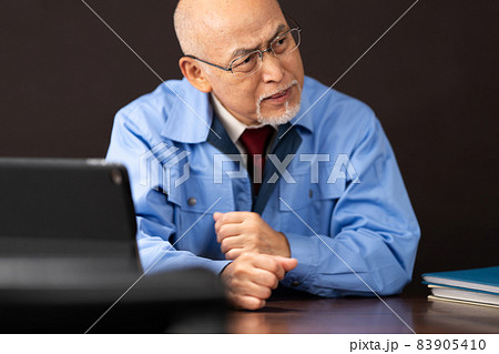 作業服のシニア男性　暗い 83905410