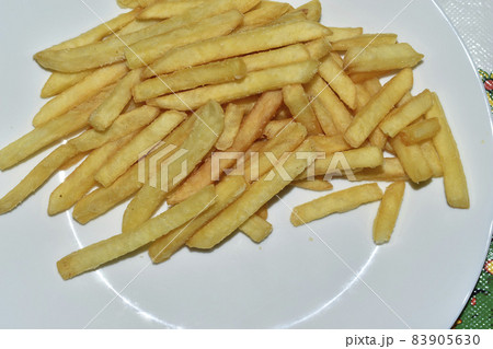Juicy yellow delicious fries on a white plate Juicy yellow delicious fries on a white plate 83905630