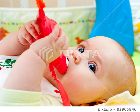 Baby girl looking out from green leaves Baby girl looking out from green leaves 83905946