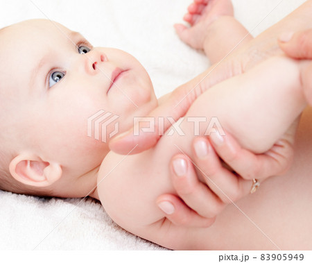 Baby girl looking out from green leaves 83905949