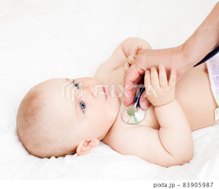 Baby girl looking out from green leaves 83905987
