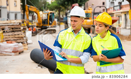 Two architects with laptop discussing construction plan Two architects with laptop discussing construction plan 83906284