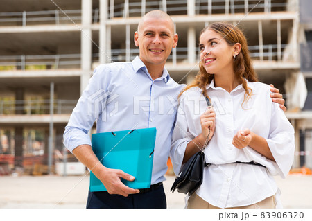 Happy couple visiting construction site Happy couple visiting construction site 83906320