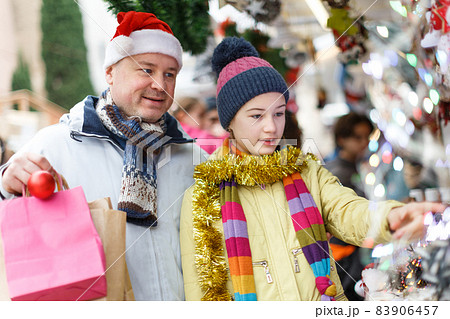 Father with daughter selecting Christmas decoration Father with daughter selecting Christmas decoration 83906457