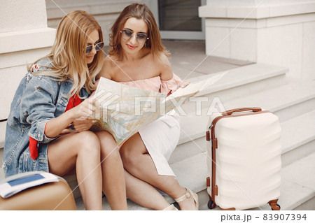 Elegant and stylish girl sitting with a suitcase 83907394