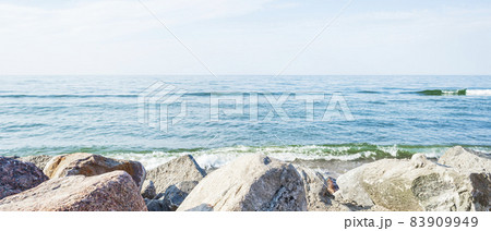 Coastal rocks on a blurry background of the sea and the sea horizon 83909949