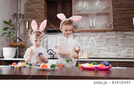 happy Easter. funny kids boy and girl with bunny ears play, prepare for the holiday and paint eggs. 83910445