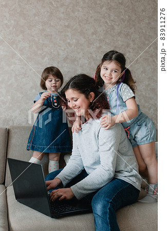 small children prevent their mother from working on the computer 83911276