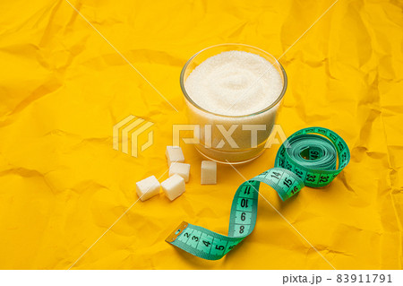 Different types of sugar and diet measuring tape on yellow background with copy space. Diet and healthy food concept. Healthy lifestyle. 83911791
