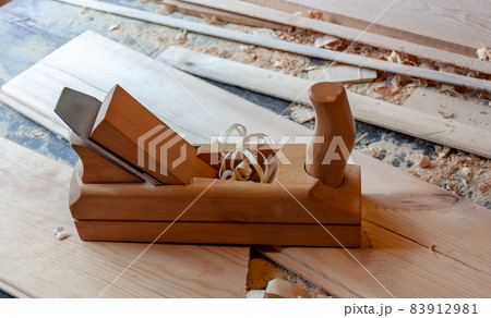Boards of light wood, wooden jointer close-up. Sawdust, shavings Boards of light wood, wooden jointer close-up. Sawdust, shavings 83912981