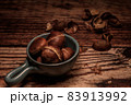 a bowl with roasted chestnuts 83913992