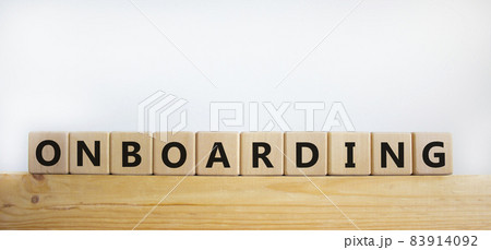 Onboarding symbol. The word 'Onboarding' on wooden cubes. Business and onboarding concept. Beautiful wooden table, white background. Copy space. 83914092