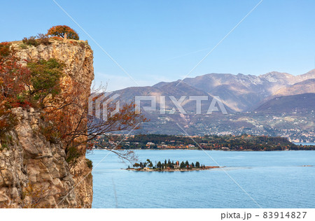 Rocky cliff of Lake Garda and a view of the little Rabbit island in autumn period Rocky cliff of Lake Garda and a view of the little Rabbit island in autumn period 83914827