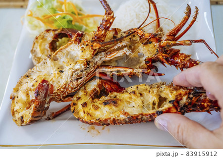 Closeup of freshly grilled lobster tails served with vegetables salad and rise. Closeup of freshly grilled lobster tails served with vegetables salad and rise. 83915912