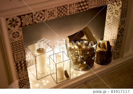 Decorated fireplace. Christmas tree. Close-up a small house, Cones, garland, and other Christmas tree toys. light from the garlands 83917117