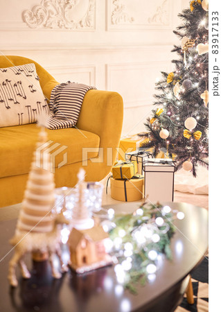 Classic apartments with decorated christmas tree and presents. Christmas evening in the light of candles and garlands. Living with fireplace and stucco. 83917133