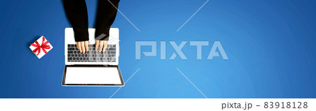 Person using a laptop computer with a gift box 83918128