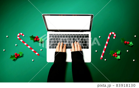 Person using a laptop computer with Christmas decorations 83918130