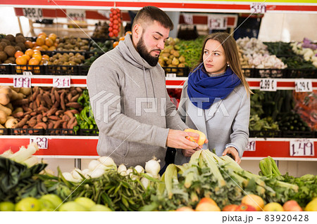Glad couple choosing vegetables in grocery shop 83920428