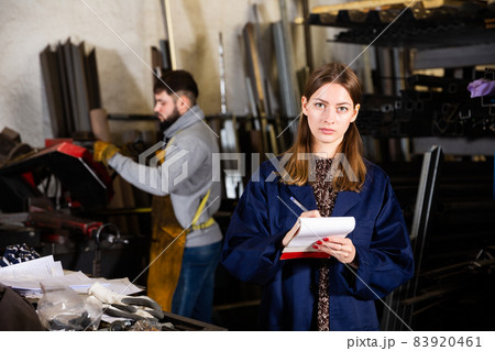 Young woman engineer taking notes in notebook Young woman engineer taking notes in notebook 83920461