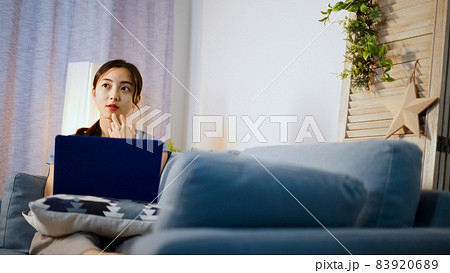 ソファーでノートパソコンを使う若い女性 83920689