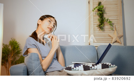 ソファーでノートパソコンを使う若い女性 ソファーでノートパソコンを使う若い女性 83920692