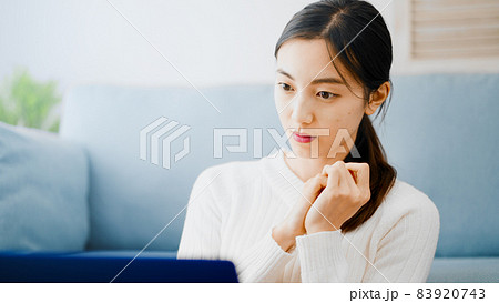 ノートパソコンを使う若い女性 83920743