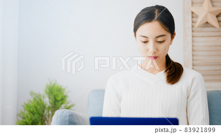 ソファーでノートパソコンを使う若い女性 83921899