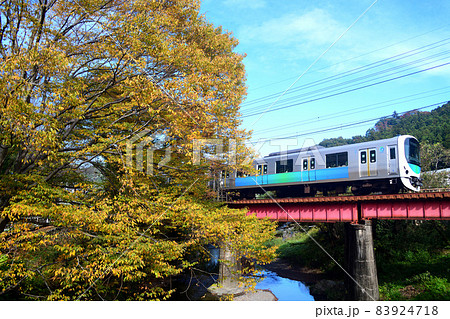 黄葉と高麗川の鉄橋を渡る西武鉄道30000系電車 83924718