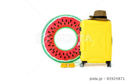 Summer travel concept. Colorful inflatable balls, sandals, yellow suitcase and straw hat with a black stripe on white background. (Studio Shot) Summer travel concept. Colorful inflatable balls, sandals, yellow suitcase and straw hat with a black stripe on white background. (Studio Shot) 83924871