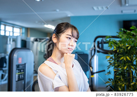 スポーツジムにいる女性(考える・悩む) スポーツジムにいる女性(考える・悩む) 83926775