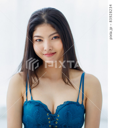Portrait of beautiful young naughty sexy Asian girl with long hairs and lovely blue bra standing with seductively smile with happy in bright morning. Portrait of beautiful young naughty sexy Asian girl with long hairs and lovely blue bra standing with seductively smile with happy in bright morning. 83928234
