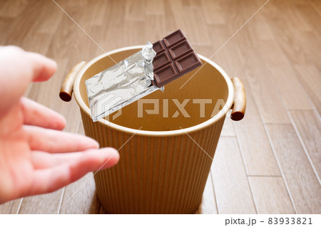 甘いものを絶つイメージで板チョコレートをゴミ箱へ捨てる 甘いものを絶つイメージで板チョコレートをゴミ箱へ捨てる 83933821