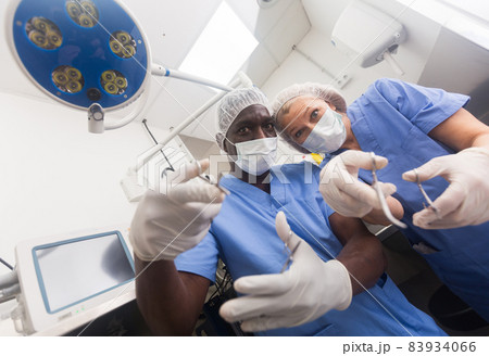 Patient from the operating table view of the surgical and assistant. Patient from the operating table view of the surgical and assistant. 83934066