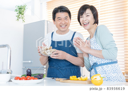 キッチンで仲良く料理をするミドルエイジの夫婦 83936619