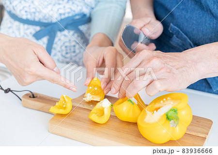 キッチンでパプリカを切る中年男性の手元のアップ 83936666