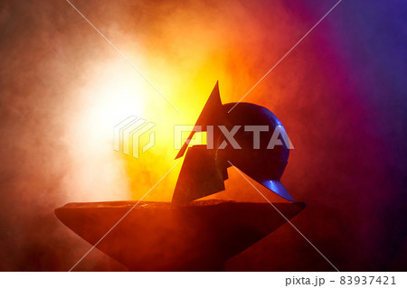 Gladiator helmet for protection in combat lying on anvil  83937421